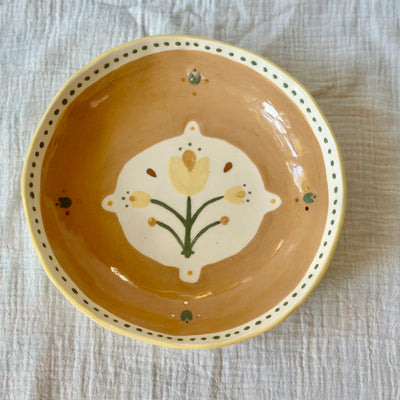 Ceramic bowl with floral design on a textured surface