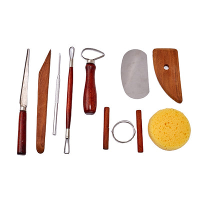 A collection of pottery tools including various wooden and metal tools, along with a sponge, neatly arranged on a white background.